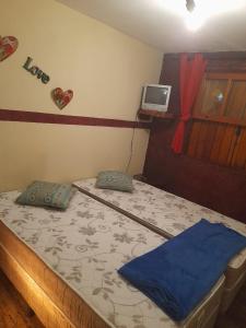 1 dormitorio con 1 cama y TV en la pared en Condomínio Alto da Boa Vista, en Campos do Jordão