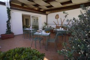 patio ze stołami, krzesłami i roślinami w obiekcie B&B Bivona w mieście Mazara del Vallo