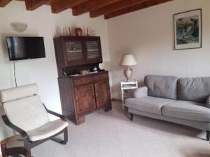 a living room with a couch and a chair at Casa di Bagattini in Posina