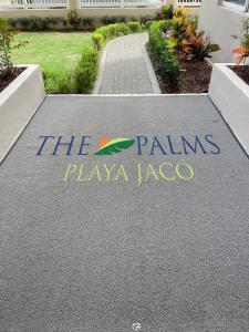 een bord dat zegt dat de palmen Playa lagosa spelen op een oprit bij The Palms Ocean Club Resort in Jacó