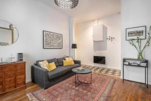 ein Wohnzimmer mit einem Sofa und einem Tisch in der Unterkunft Chaleureux appartement pour 5 à deux pas de la Place Graslin in Nantes