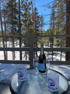 un tavolo di vetro con una bottiglia di vino e due bicchieri di Cinnamon Bear Inn a Mammoth Lakes Altre 19 foto