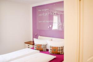 2 camas en una habitación con paredes moradas en Ferienhaus Alb-Traum, en Hayingen