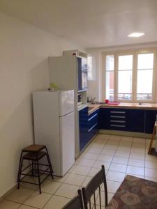 a kitchen with a white refrigerator and blue cabinets at Appartement charmant à Dieulouard, 75 m² avec Parking in Dieulouard +23 photos