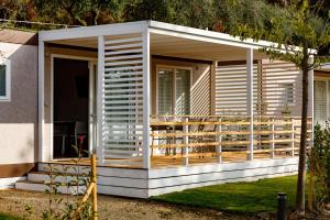 a modular house with a deck on the side at Agriturismo Agricamping GARDA NATURA in Costermano