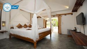 a bedroom with a canopy bed with a tv at Fisherman Koh Tao in Ko Tao