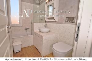 a bathroom with a sink and a toilet and a mirror at Casa Biltu in Lavagna