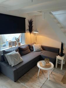 a living room with a couch and a table at Vakantiehuis Katwijk Andreasplein in Katwijk
