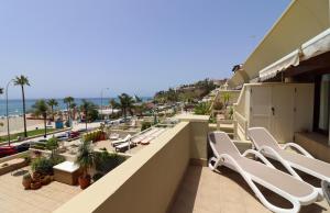 balkon z białymi leżakami i widokiem na plażę w obiekcie Apartment Burriana Spainsunrentals 1162 w mieście Nerja
