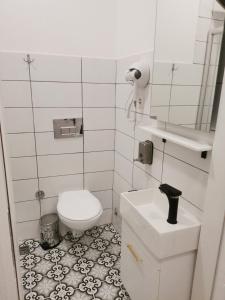 a white bathroom with a toilet and a sink at St Moscow Suites Taksim in Istanbul