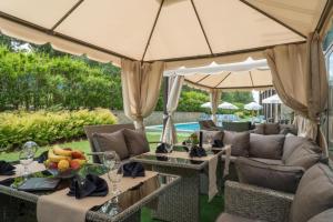 a patio with tables and chairs under a large umbrella at The View Apartment, Terra Complex neighbour building in Bansko