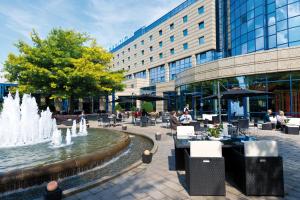 a fountain in front of a building with people sitting at tables at Maritim Hotel Bonn in Bonn
