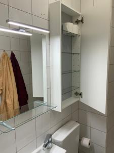 a bathroom with a toilet and a sink and a mirror at Quartier bas Montreuil à 3minutes du métro in Montreuil