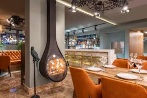 ein Restaurant mit einem Kamin in der Mitte eines Tisches in der Unterkunft Bristol Hotel and Spa Bakuriani in Bakuriani