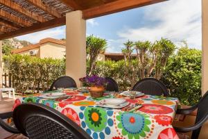 a table with a colorful table cloth on a patio at Casa Marcella in Costa Rei