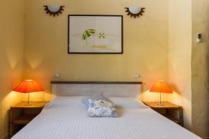 a bedroom with a bed with two lamps on it at Casa Marcella in Costa Rei