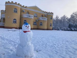 ハイドゥソボスローにあるKastély Panzióの雪の中の建物前の雪だるま