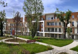 un gran edificio de apartamentos con un parque enfrente en Domitys Les Raisins Bleus, en Villiers-sur-Marne