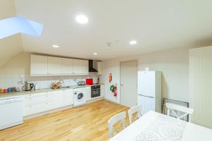 a kitchen with a table and a white refrigerator at Wallace Apartment in Newton Stewart