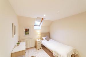a bedroom with a bed and a desk and a window at Wallace Apartment in Newton Stewart