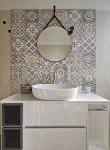 W łazience znajduje się biała umywalka i lustro. w obiekcie Casa Mare d'Arancio w mieście Bordighera