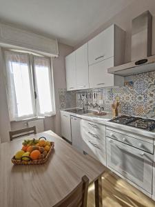 a kitchen with a bowl of fruit on a table at Casa Mare d'Arancio in Bordighera