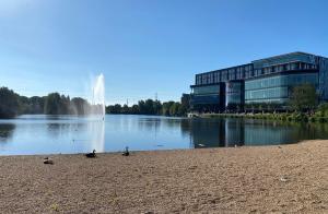 a fountain in the middle of a lake with a building at Genting Hotel & Spa at Resorts World Birmingham in Bickenhill