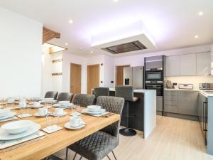 a dining room with a table and chairs and a kitchen at Valley View in Helston