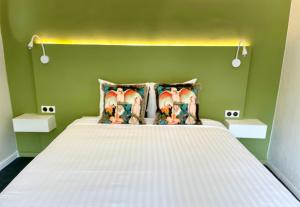 a bedroom with a white bed with a green wall at Centr'Hotel in Marigot