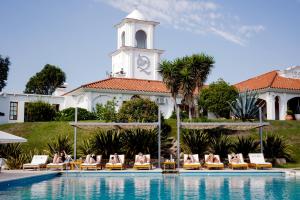 a group of people sitting in lounge chairs by a swimming pool at La Posada Del Qenti - All Inclusive Saludable in Villa Carlos Paz