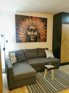 a living room with a couch and a painting at Kai Apartman in Kopaonik