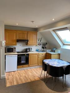 a kitchen with wooden cabinets and a table and a window at Pound Corner in Godalming