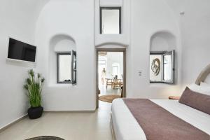 a bedroom with a bed and a tv on the wall at U & ME SUITES in Fira