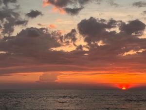 a sunset over the ocean with a cloudy sky at Amanda Beach Villas in Unawatuna