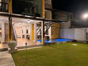a house with a pool in the yard at night at Amanda Beach Villas in Unawatuna