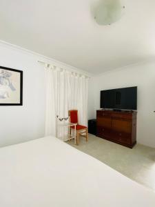 1 dormitorio con 1 cama y TV de pantalla plana en Mision Costa, en Corralejo