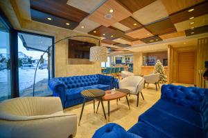 una sala de estar con sofás y sillas azules en Aria Club Wellness&Spa Zlatibor en Zlatibor