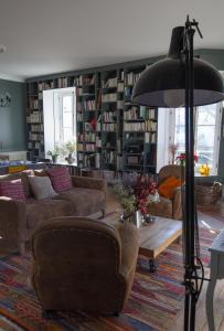 a living room with couches and a large library at NAMASTE COTTAGE in Issigeac