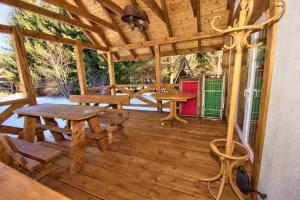 a wooden porch with a wooden table and bench on it at Konie2 Pokoje Gościnne in Wetlina