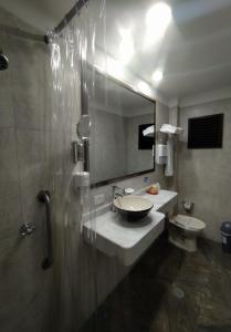 a bathroom with a sink and a toilet and a mirror at Hotel Camino Real Popayán Colombia in Popayan