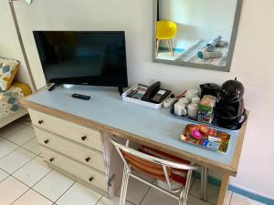 a desk with a television on top of a dresser at Studio Carayou & Spa in Les Trois-Îlets