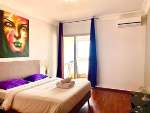 カサブランカにあるAnfa 138 - Best view in town. Great location. Luxurious 2 bedroomsのベッドルーム1室(紫色の枕と絵画が備わるベッド2台付)