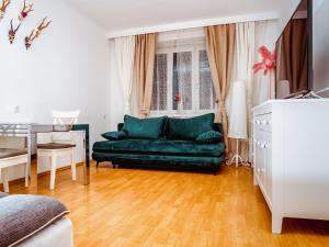 een woonkamer met een groene bank en een tafel bij Wohnen im Herzen von Wien at the Waterfront in Wenen