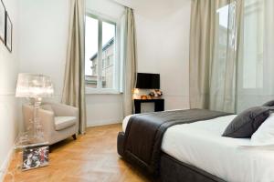 Vanity Hotel Navona في روما: غرفة نوم بسرير وكرسي ونافذة
