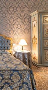 a bedroom with a bed and a table with a lamp at palazzo suite ducale in Venice