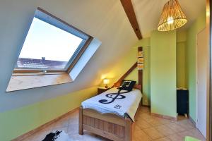 a attic room with a bed and a window at Location Elfe in Stosswihr