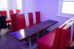 a dining room with a wooden table and red chairs at Brighton Beach Inn in Brighton & Hove
