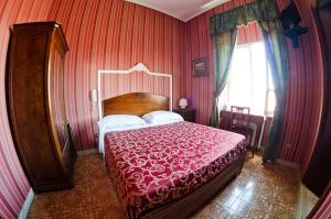 a bedroom with a large bed with a red blanket at Hotel Villa Maria in Naples