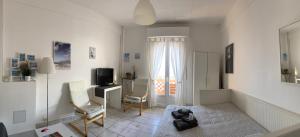 a white living room with a television and a chair at Amazing View Port Golfe-Juan and Garage in Golfe-Juan