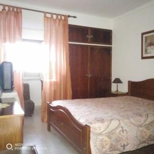 a bedroom with a bed and a television and a window at Apartamento Central in Vila Real de Santo António